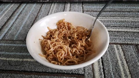 Hand hold a fork while twist hot fried noodles in a bowl Stock Footage 130427571