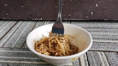 Hand hold a fork while twist hot fried noodles in a bowl Stock Footage 130427686