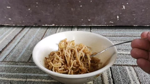 Hand hold a fork while twist hot fried noodles in a bowl Stock Footage 130427850