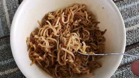 Hand hold a fork while twist hot fried noodles in a bowl Stock Footage 130428151