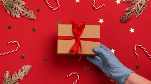 Hand hold gift box in protective medical gloves COVID 19. Christmas 2021 Stock Footage 144136804