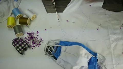 Hand hold scissors cut white cloth pattern, prepare to sew protective mask ,  Stock Footage 131340231