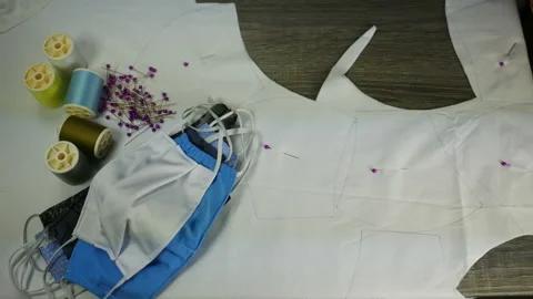 Hand hold scissors cut white cloth pattern, prepare to sew protective mask ,  Stock Footage 131340469