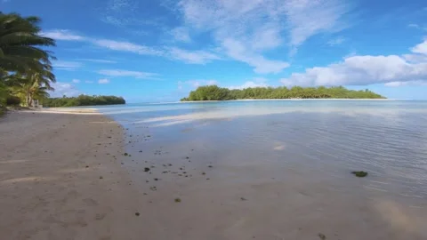 Hand hold slow horizontal pane view of beach sandy side look out to Koromiri isl Stock Footage 253461519