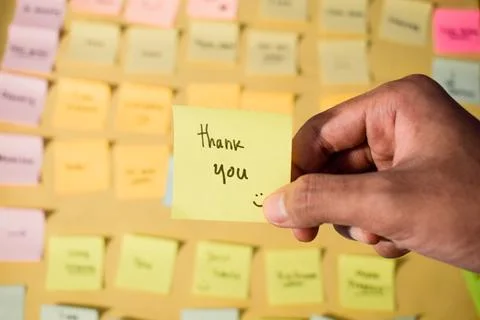 Hand hold sticky notes with words Thank you. Motivational words for personal Stock Photos