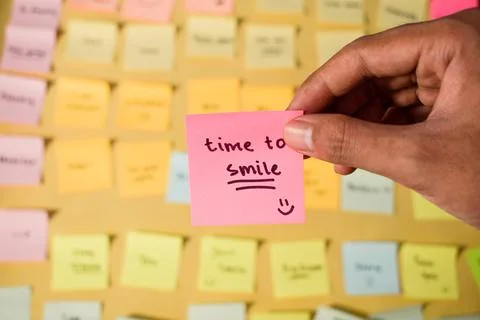 Hand hold sticky notes with words Time to Smile. Motivational words for personal Stock Photos