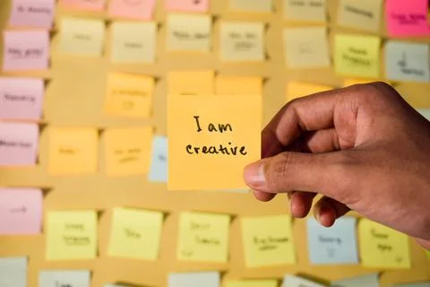 Hand hold sticky notes with words I am creative. Motivational words for personal Stock-Fotos