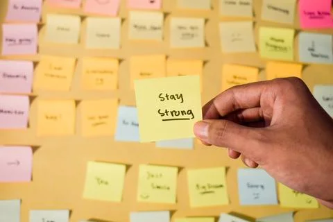 Hand hold sticky notes with words stay strong, Motivational words for personal Stock Photos