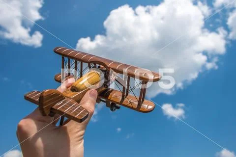 The hand hold a toy plane on the background of the cloud Stock Photos