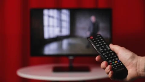 Hand Hold Tv Remote Control. Tv On The Background. Stock Footage 103178147