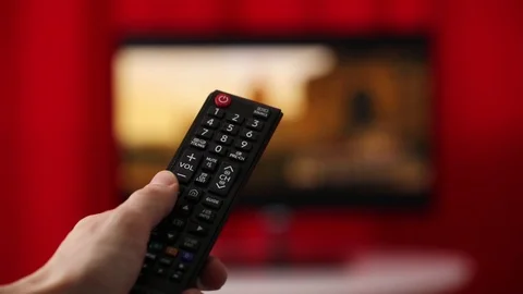 Hand Hold Tv Remote Control. Tv On The Background. Stockbeeldmateriaal 103180049