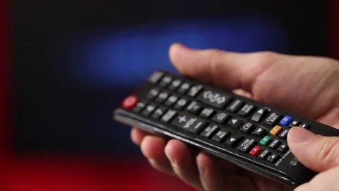 Hand Hold Tv Remote Control. Tv On The Background. Stockbeeldmateriaal 103181495