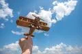 The hand hold a wood airplane on the cloud background Photo
