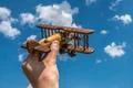 The hand hold a wood plane on the background of the cloud Photo