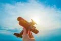 The hand hold the wooden plane on the background of the sunrise Photo