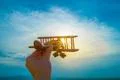 The hand hold the wooden plane on the background of the sunrise Photo
