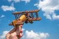 The hand hold a wooden plane on the background of the cloud Photo
