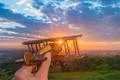 The hand hold wooden plane on the background of a sunset Photo