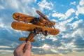The hand hold wooden plane on the background of a blue sky Photo