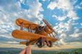 The hand hold wooden plane on the background of a blue sky Photo
