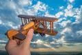 The hand hold wooden plane on the background of a blue sky Photo
