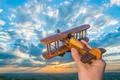 The hand hold wooden plane on the background of a sky Photo