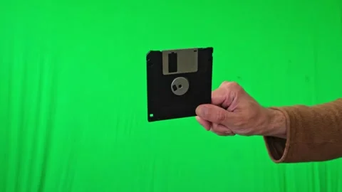 Hand Holding 3.5-inch Floppy Disk on Green Screen Stock Footage 313913952