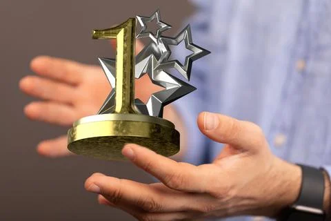 Hand holding a 3D render of a first place trophy 스톡 사진