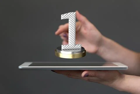 Hand holding a 3D render of a first place trophy over a tablet 스톡 사진