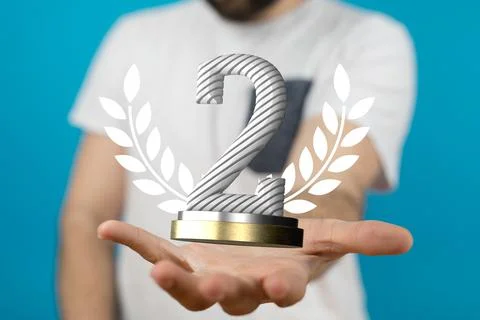 Hand holding a 3D render of a second place trophy 스톡 사진