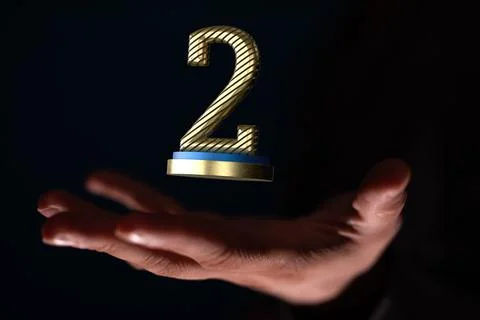 Hand holding a 3D render of a second place trophy 스톡 사진