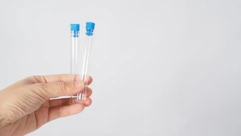 Hand is holding 5 empty test tubes on white background. Stock Photos