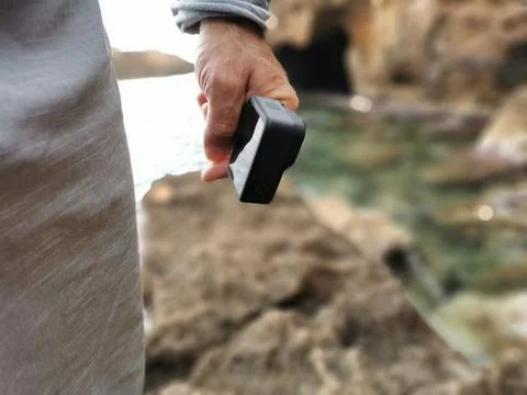 Hand holding action camera isolated. Monopod hold in arm. Active cam. Stock Photos