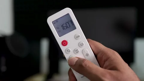 Hand Holding Air Conditioner Remote Control increasing decreasing temperature Stock Footage 334002339