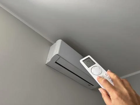 Hand holding an air conditioner remote control  Stock Photos