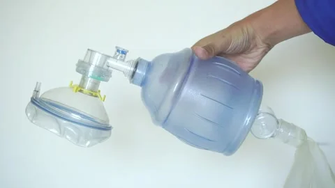 Hand holding an Ambu bag for providing respiratory assistance. Video stock 322109678