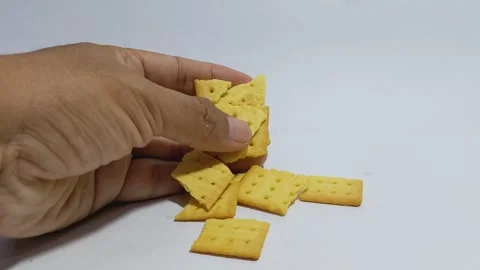 Hand holding and breaking crackers on a surface Stock Footage 336701251
