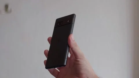 Hand Holding and Displaying Google Pixel 7a Smartphone Indoors Stock Footage 327342709