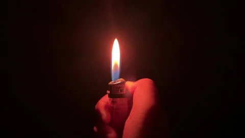 Hand holding and igniting clear plastic lighter with a bright flame. video Video stock 314460236