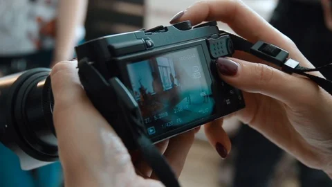 Hand holding and setting up a digital SLR camera. Close up of photographer hands Stock Footage 91076560