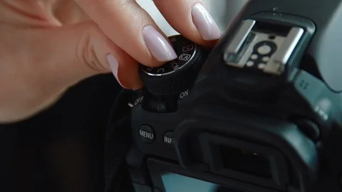 Hand holding and setting up a digital SLR camera. Close up of photographer hands Stock Footage 91076583