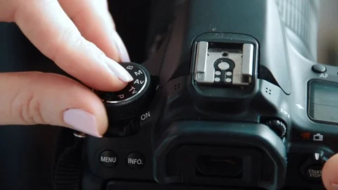 Hand holding and setting up a digital SLR camera. Close up of photographer hands Stock Footage 91076592