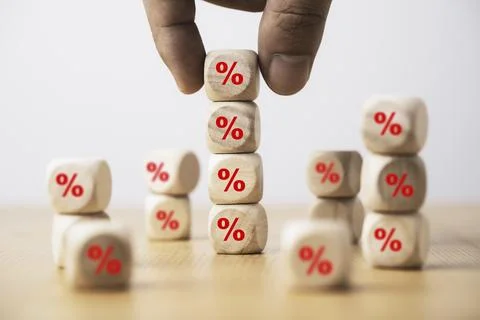 Hand holding and stacking red percentage sign print screen on wooden cube b.. Stock Photos