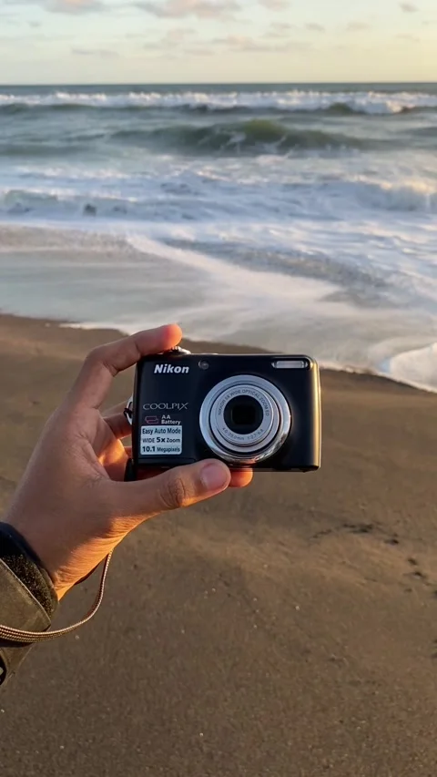 Hand holding and turning on a black digital camera Stock Footage 295011895