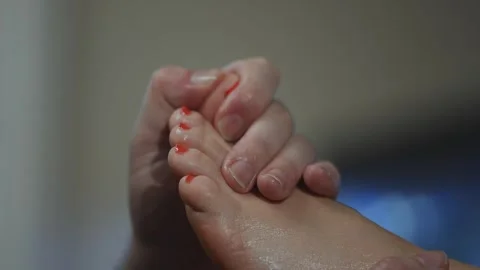 A hand holding another hand with red nail polish on it Stock Footage 302481471