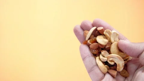 Hand holding assortment of mixed nuts and dried fruits in slow motion again.. Stock Footage 333152835