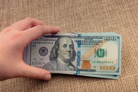 Hand holding banknote bundle of US dollar in hand Stock Photos