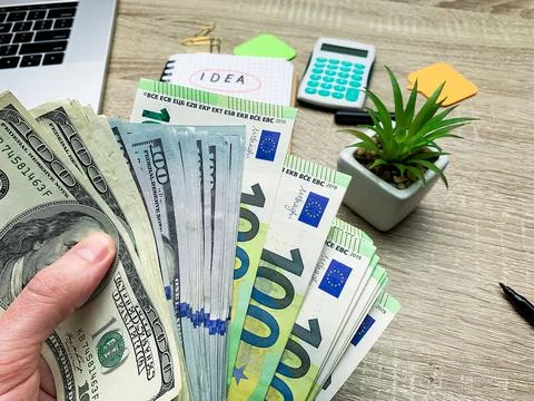 Hand holding banknote bundle of US dollar and euro Stock Photos