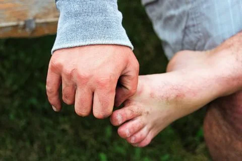 A hand holding onto a bare foot while sitting Stock Photos