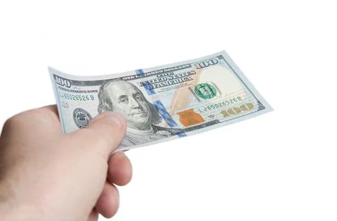 A hand holding a bill hundred dollars. The concept of payment for services. I Stock Photos